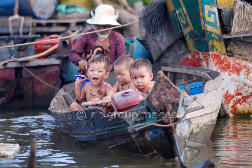 Cambodia -326 
 Three boys in a boat - at Floating Village of Chong Kneas on Tonle Sap 
 Keywords: Asia, Boy, Cambodia, canoe, childhood, Children, children's games, , People, Siem Reap, transport, transportation, water transportation