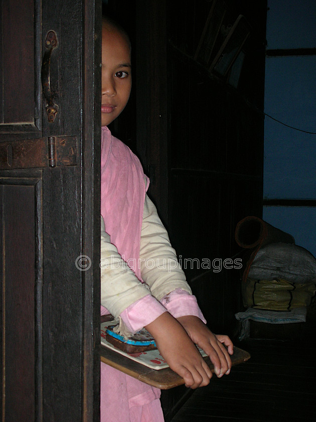 Burma - 00986 
 Young nun hiding behind a door, Tha Ka Nunnery, Hills of Sagaing Tour Kay Mar 
 Keywords: Asia, Portrait, religion, OCCUPATION, Burma, Bagan, Girl, Myanmar, nun