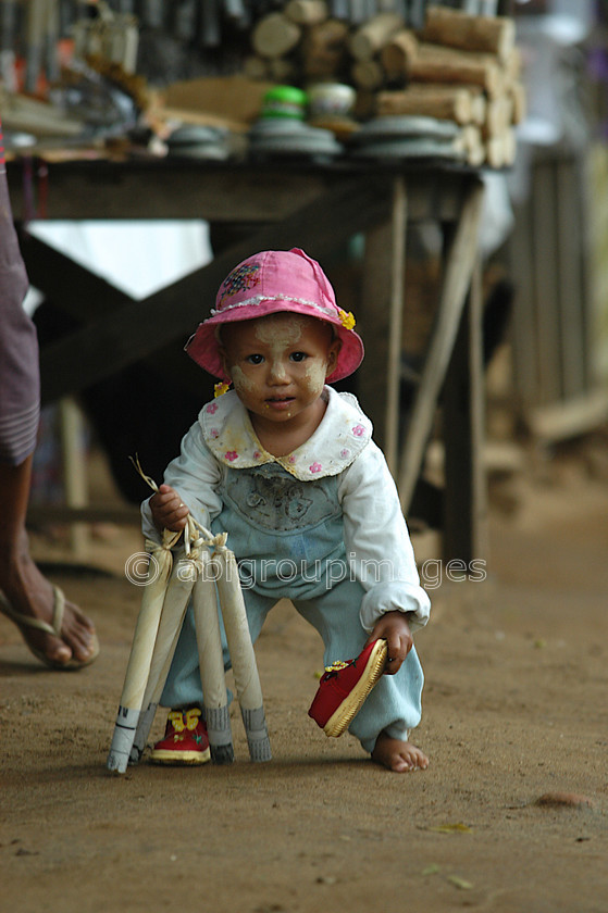 Burma - 00758 
 Child playing and picking up lost shoe, Mandalay - Mingun Tour 
 Keywords: Portrait, Burma, Bagan, child, Asia, Myanmar