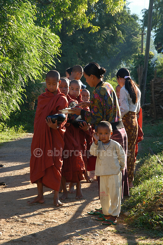 Burma - 01577 
 Inle Lake - Monks early morning food pickup from the local villagers 
 Keywords: Asia, Myanmar, male, monk, religion, Boy, Burma, Child